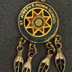 St. Joseph’s Indian School pendant Metal with 4 metal feathers.
